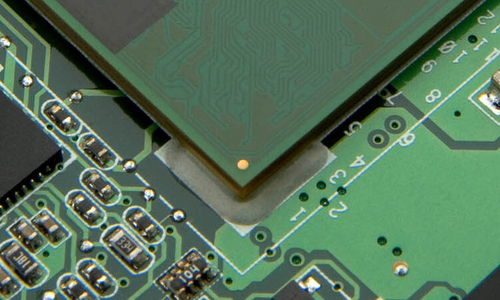 An edgebond material is shown on the corner of a printed circuit board component.